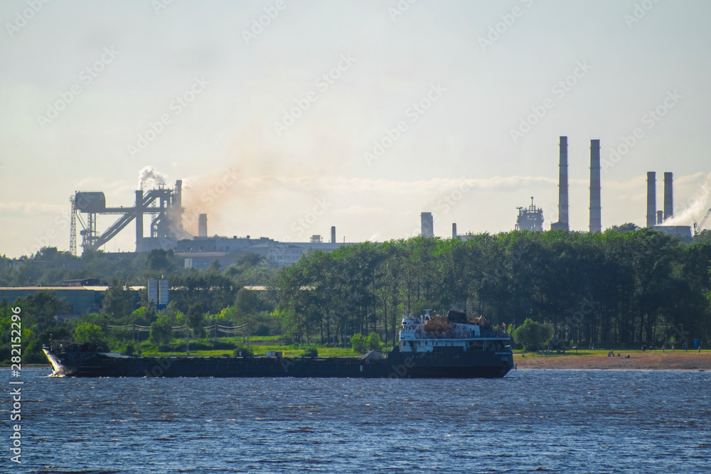 Cherepovets, Russia - June, 9, 2019: image of cargo ships on the background of the city of Cherepovets, Russia