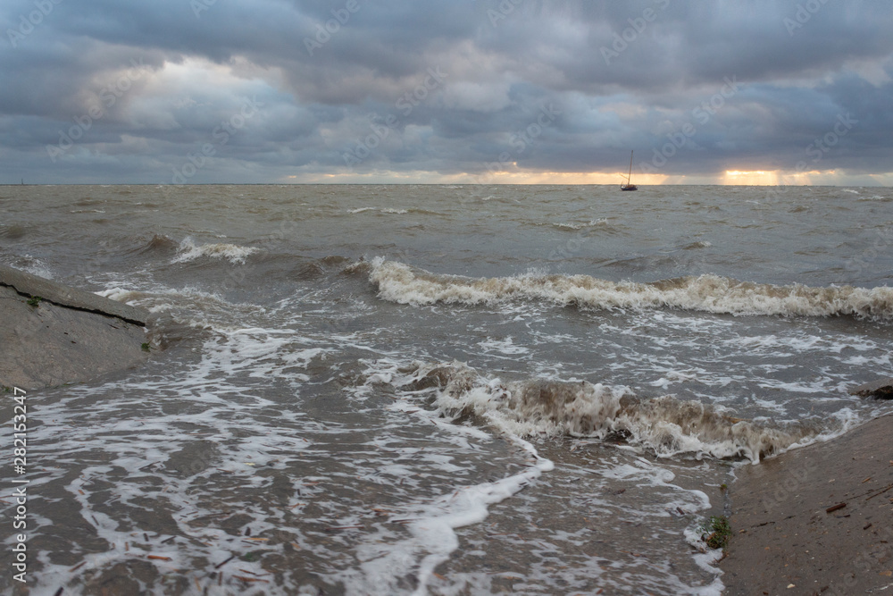 Storm on the Sea of Azov on a summer evening, sea waves flood the dock, Primorsko-Akhtarsk, Krasnodar Territory, Russia