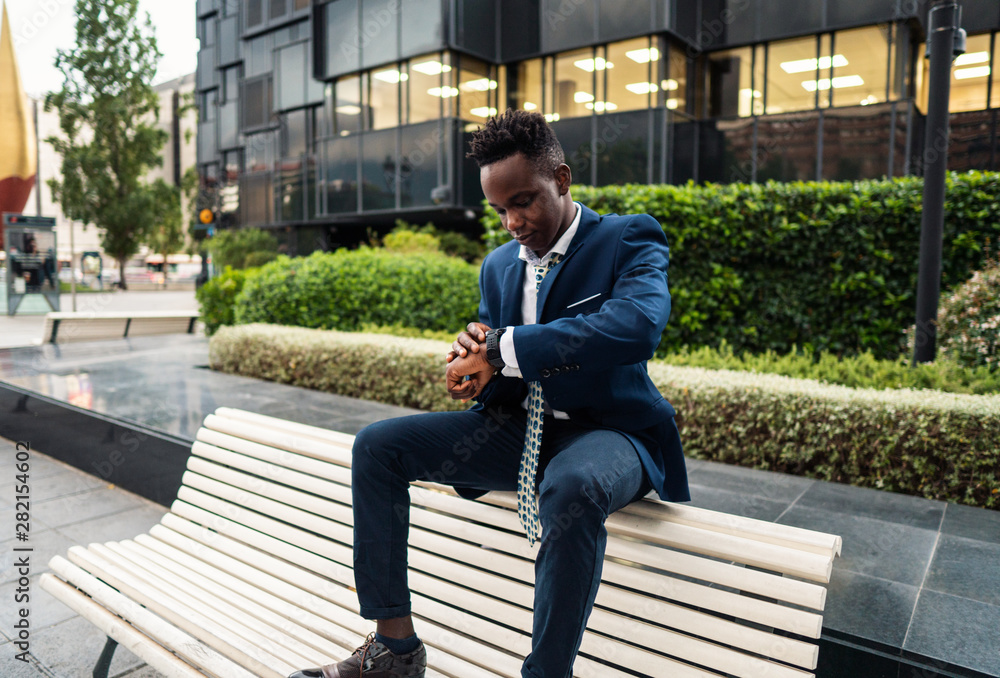 Businessman looking at his watch ourdoors near office. Time concept Businessman looking at his watch ourdoors near office. Time concept