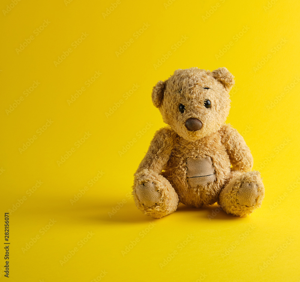teddy bear sitting on a yellow background Stock Photo | Adobe Stock