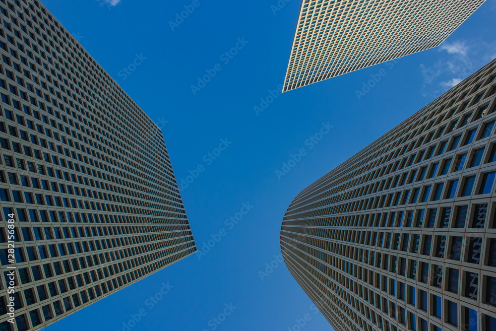 modern city landmark photography of three high glass skyscrapers from below perspective foreshortening on blue sky background with empty copy space for text modern city landmark photography of three high glass skyscrapers from below perspective foreshortening on blue sky background with empty copy space for text