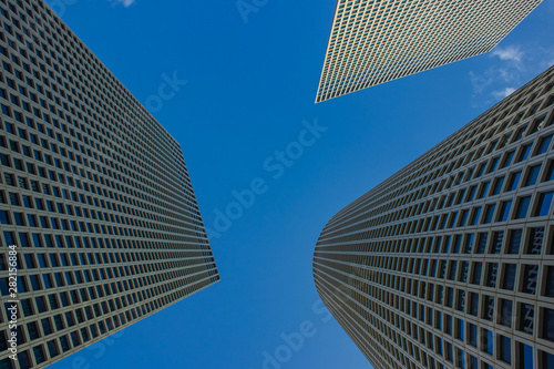 modern city landmark photography of three high glass skyscrapers from below perspective foreshortening on blue sky background with empty copy space for text