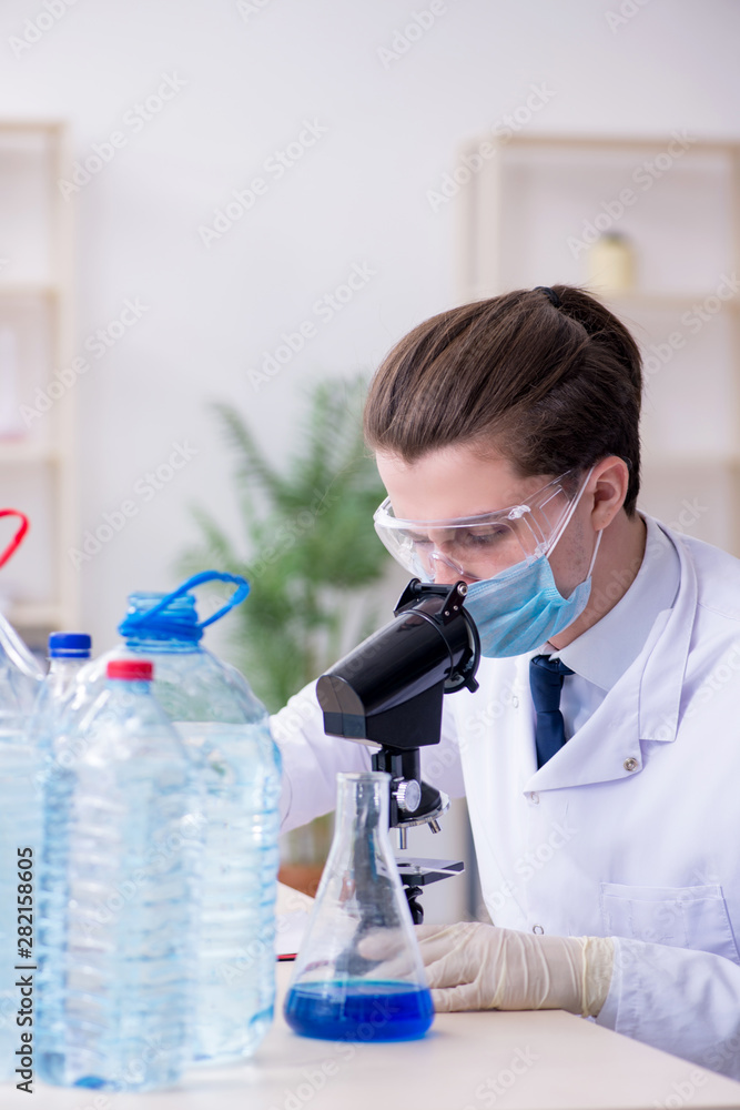 Young male chemist experimenting in lab Young male chemist experimenting in lab