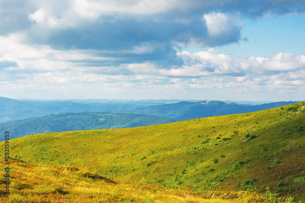 beautiful landscape of carpathian mountains. grassy alpine meadows, deep valleys and distant forested hills. wonderful sunny weather at sunset in summertime. fluffy clouds on the blue sky