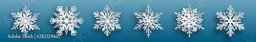 Christmas set of white complex paper snowflakes with soft shadows on light blue background