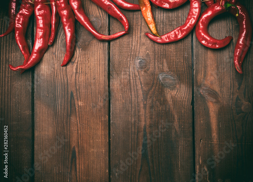 ripe red chili peppers on a brown wooden vintage background