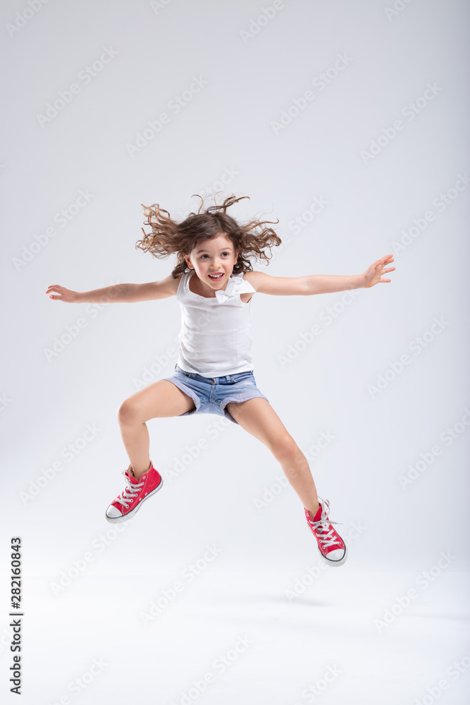 Hyperactive little girl leaping into the air Hyperactive little girl leaping into the air