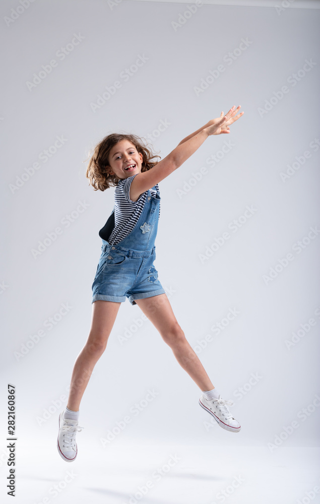 Graceful girl stretching her arms as she jumps