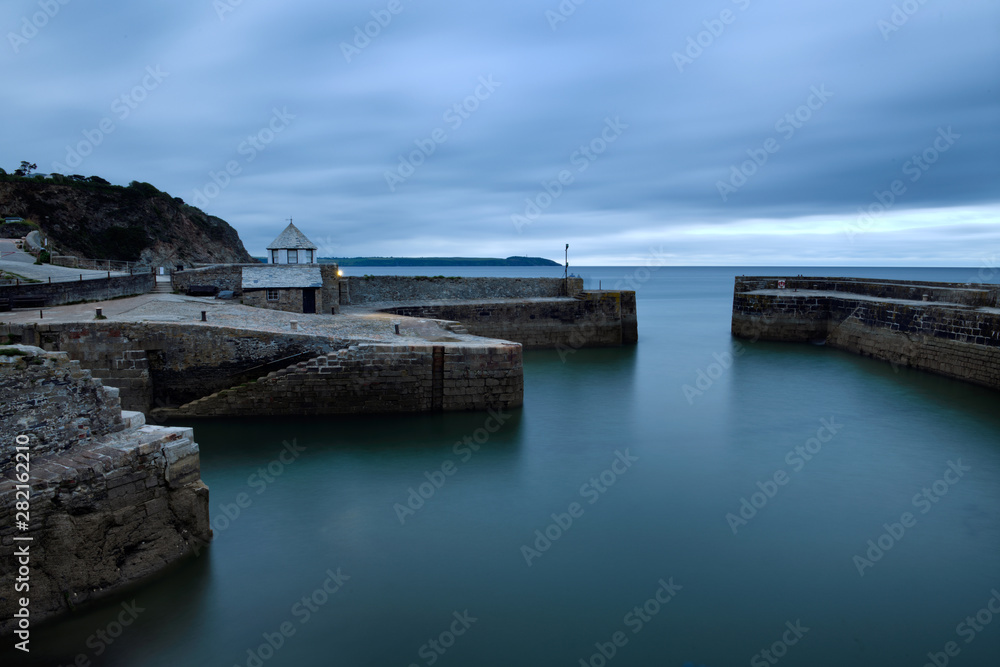 Harbour entrance and outer harbour of fishing village of Charlestown Cornwall England at twilight