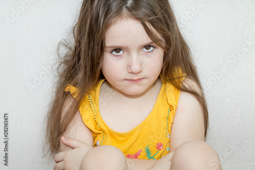 a portrait of emotional upset pensive and meditative little girl on a white background