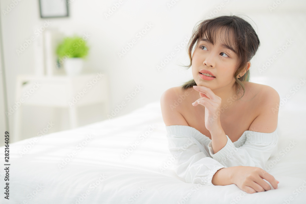 Beautiful portrait young asian woman lying and smile while wake up with sunrise at morning, beauty cute girl happy and cheerful resting on bed in the bedroom, lifestyle and relax concept. Beautiful portrait young asian woman lying and smile while wake up with sunrise at morning, beauty cute girl happy and cheerful resting on bed in the bedroom, lifestyle and relax concept.