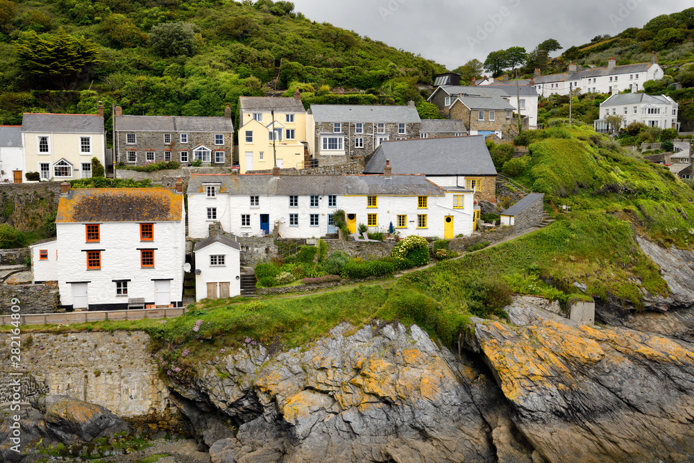 Colorful window frames on white washed houses on cliff of seaside village of Portloe Cornwall England