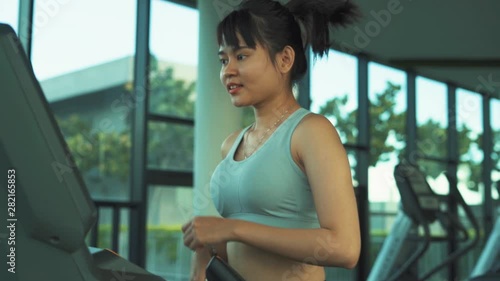 In gym, Beautiful Asian Woman Athlete Runs on a Treadmill in sportwear, fitness concept. Slow Motion.