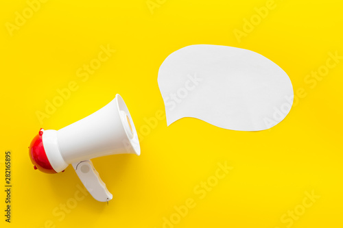 Megaphone with bubble for announcement text on yellow background top view space for text
