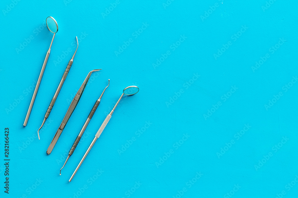 Dentist tools for cure teeth on blue background top view copy space Dentist tools for cure teeth on blue background top view copy space
