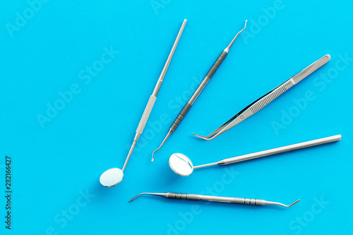 Dentist tools for cure teeth on blue background top view