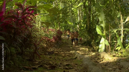 Indigenous Kids Running Through A Path Around Amazon Village In Ecuador