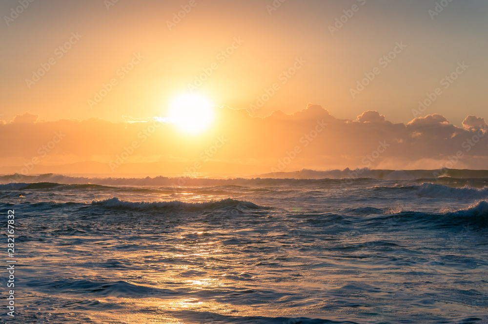Sunrise, sunset seascape with golden sun over horizon