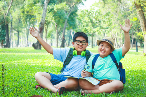 Two boys sitting at the natural map