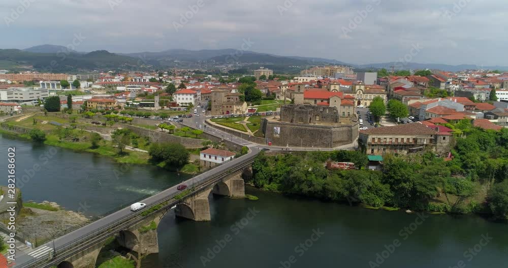 Aerial: Cars Drive Across the Bridge of Barcelos and Around the Palace of Dukes on a Sunny Day in Barcelos - Barcelos, Portugal Aerial: Cars Drive Across the Bridge of Barcelos and Around the Palace of Dukes on a Sunny Day in Barcelos - Barcelos, Portugal