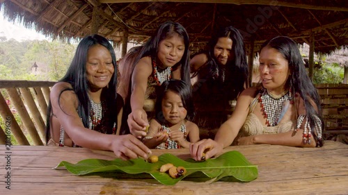 Amazonian Indigenous Child And Woman Eating Chontaduro Worms In Ecuador photo