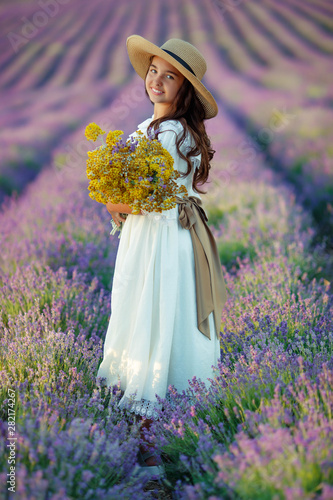 Girl in nature. Little girl in a field with flowers. Lavender, right. 