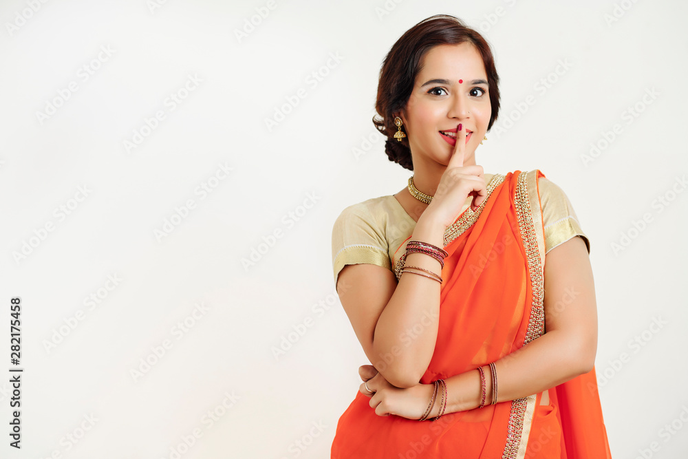 Cheerful excited young woman making silence gesturte and looking at camera Cheerful excited young woman making silence gesturte and looking at camera