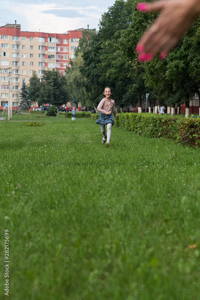 Little cheerful girl running through the grass. Little cheerful girl running through the grass.