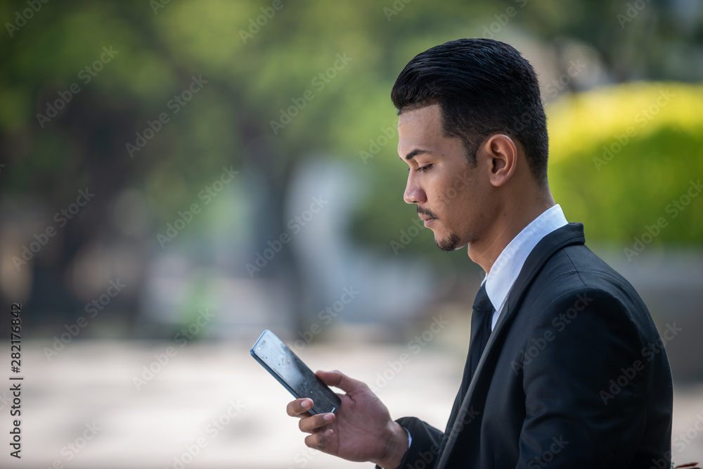 Malaysian Man with his smartphone Malaysian Man with his smartphone