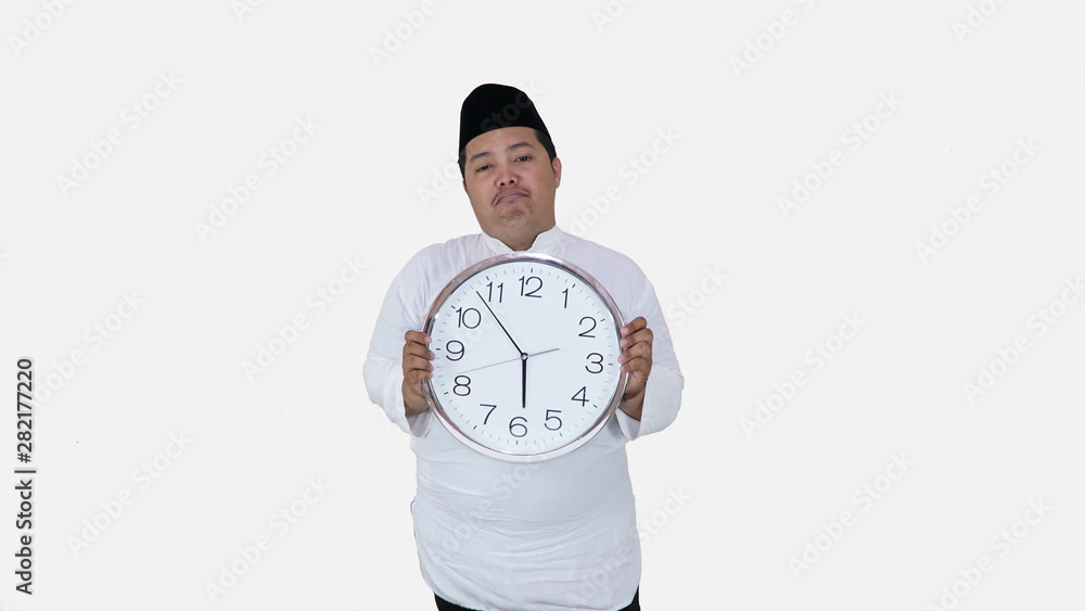 muslim asian with overweight standing and holding big round clock waiting for break fasting. islam fat boy can't waiting for muslim break fasting muslim asian with overweight standing and holding big round clock waiting for break fasting. islam fat boy can't waiting for muslim break fasting