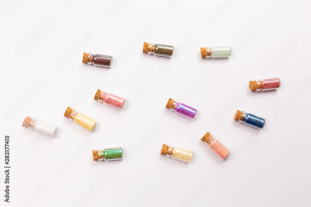 Cosmetics, makeup and beauty concept - Colourful eye shadow in small glass boxes on white background, top view close up. Cosmetics, makeup and beauty concept - Colourful eye shadow in small glass boxes on white background, top view close up.