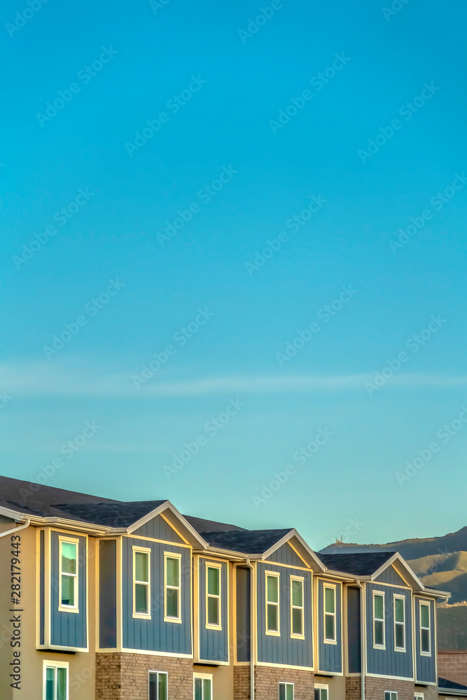 Townhomes exterior with blue sky and mountain background on a sunny day Townhomes exterior with blue sky and mountain background on a sunny day