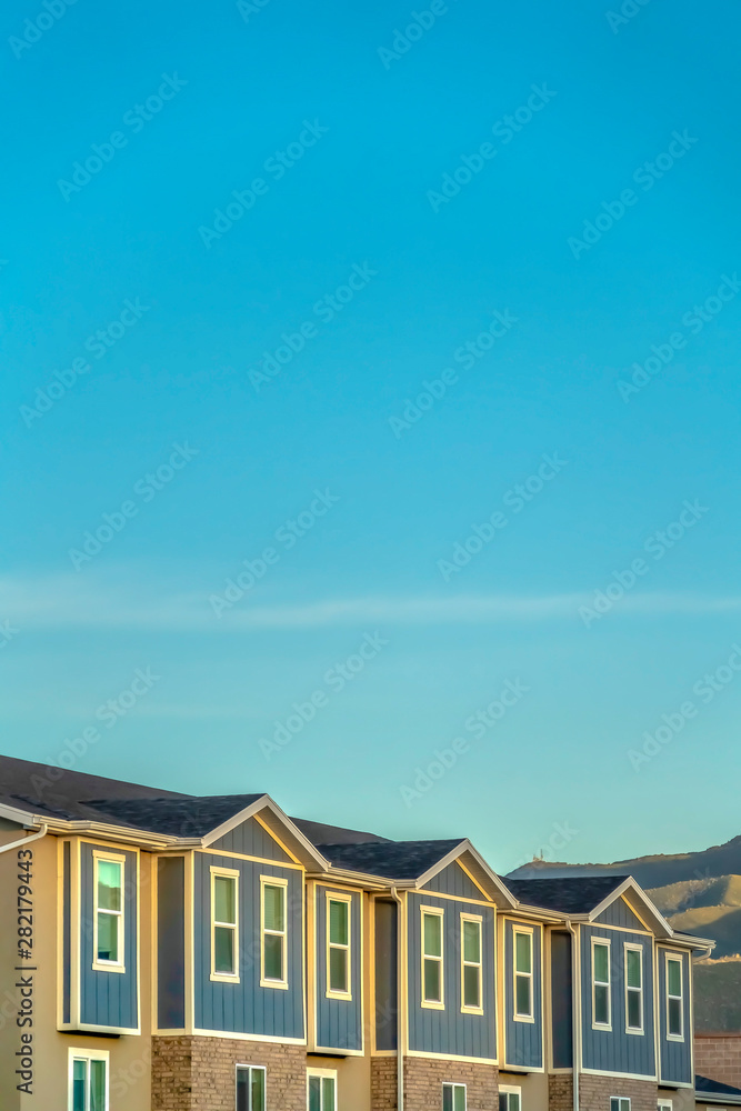 Townhomes exterior with blue sky and mountain background on a sunny day