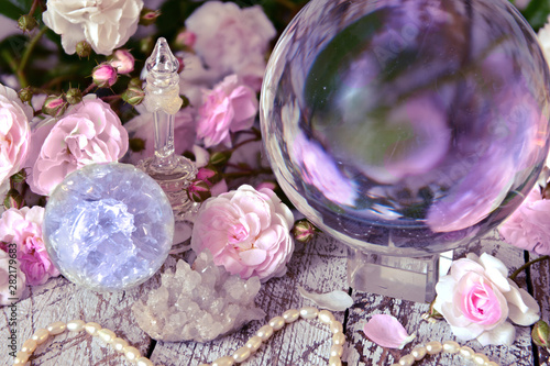 Foto Still life with magic crystal ball, pink roses and necklace.