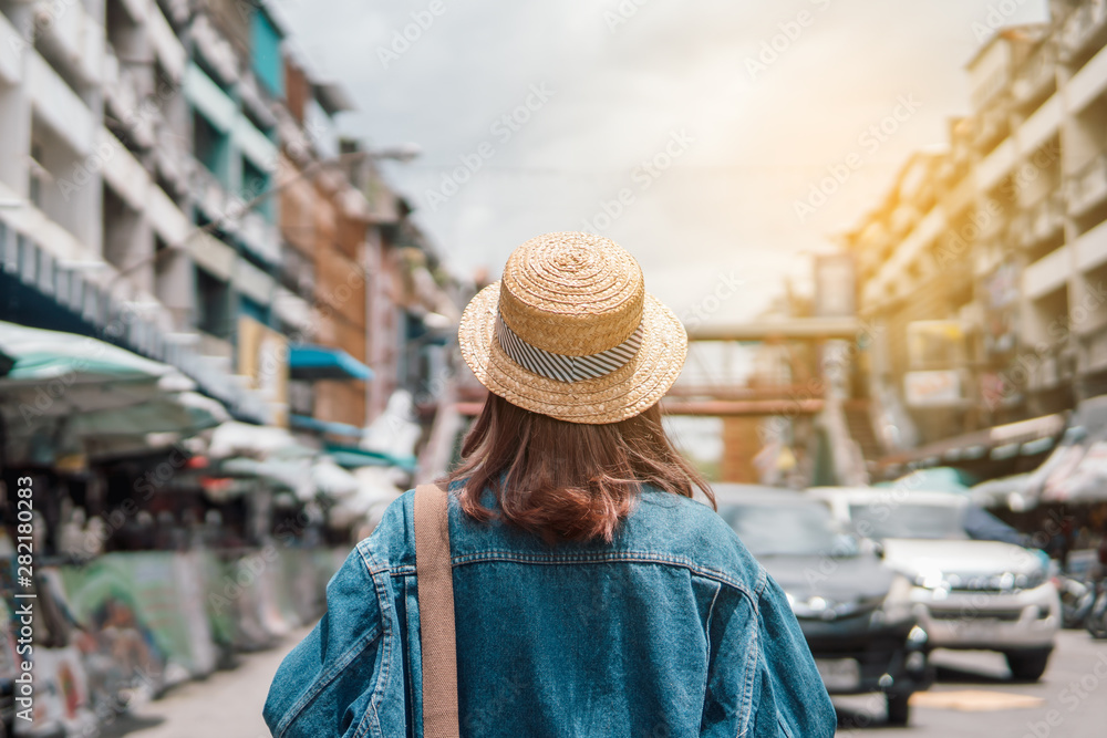 woman traveler with backpack holding map and looking at amazing town.