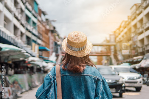 woman traveler with backpack holding map and looking at amazing town.