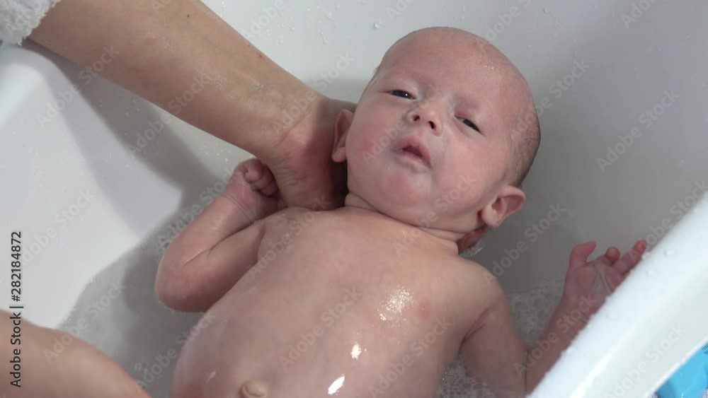 Mother take a bath for his newborn baby. Baby bath time Mother take a bath for his newborn baby. Baby bath time