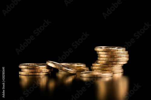 The concept of deposit accumulation, the concept of money growth. Scattered coins. Stack of gold coins on a black background.