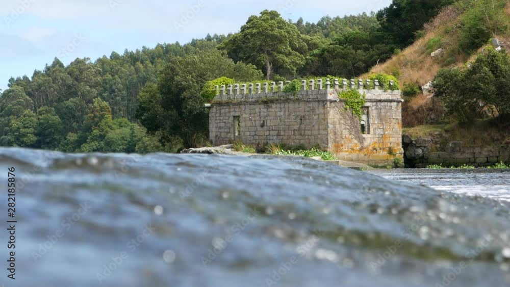 Old stone castle ruin by Ave River in Vila do Conde, Portugal with trees in background. Low angle. Old stone castle ruin by Ave River in Vila do Conde, Portugal with trees in background. Low angle.