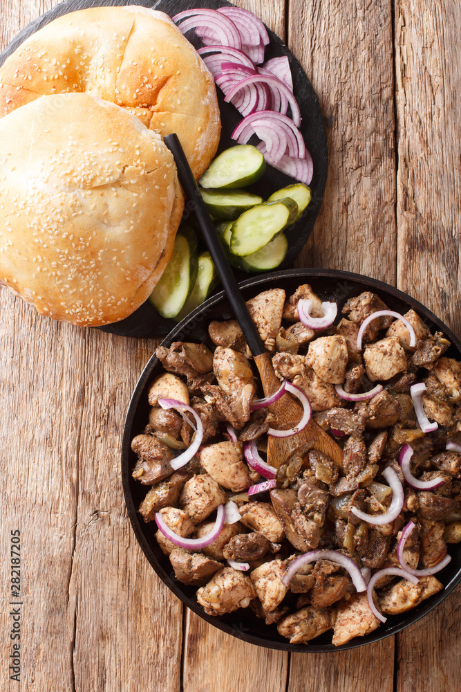 Jerusalem mixed grill or meorav Yerushalmi tasty chicken and offal fried with onions and spices close-up on a plate. Vertical top view Jerusalem mixed grill or meorav Yerushalmi tasty chicken and offal fried with onions and spices close-up on a plate. Vertical top view