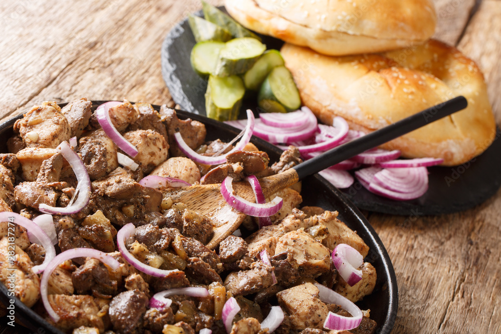 Fototapeta premium Tasty Jerusalem mixed grill or meorav Yerushalmi served with pita and pickles close-up on a plate. horizontal