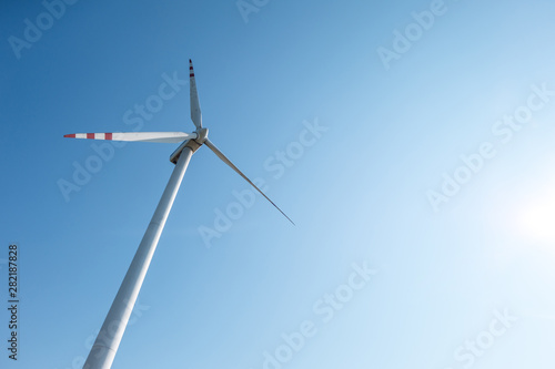 rotating blades of a windmill propeller on blue sky background. Wind power generation. Pure green energy. © hiv360