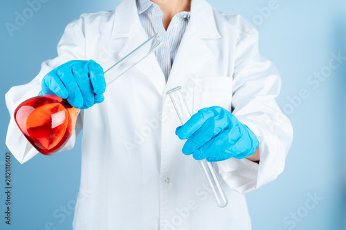 Young scientist with test tube making research in clinical laboratory.Professional science specialist at work.