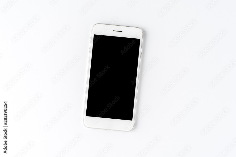 Smart phone with blank screen on white desktop. Top view Smart phone with blank screen on white desktop. Top view
