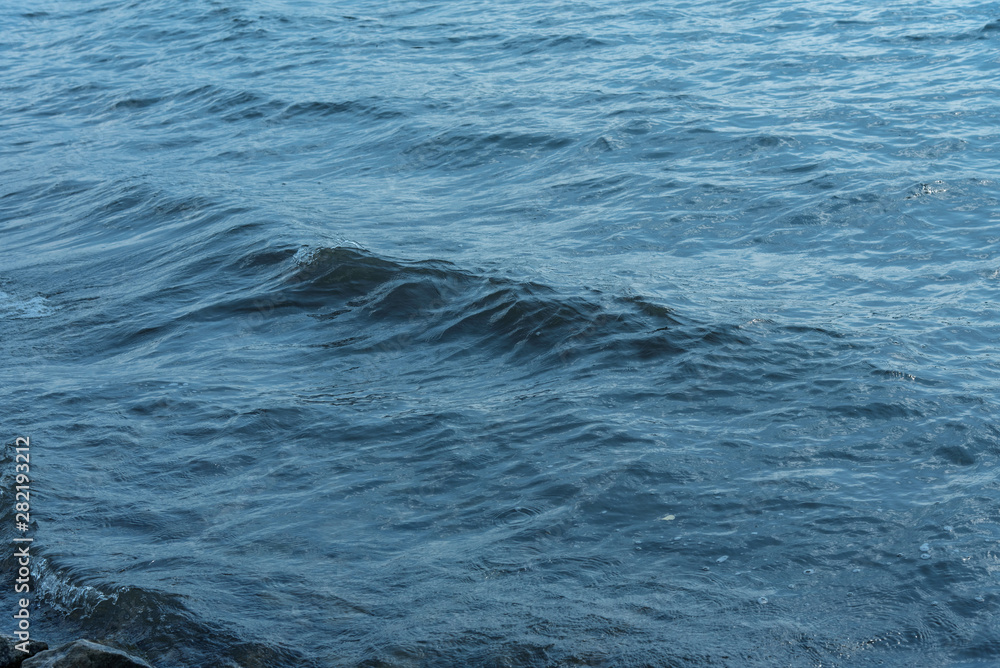 Fototapeta premium Blue water with waves and sun reflections background