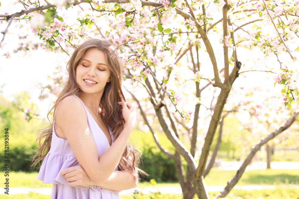 Beautiful young woman near blooming tree on spring day Beautiful young woman near blooming tree on spring day
