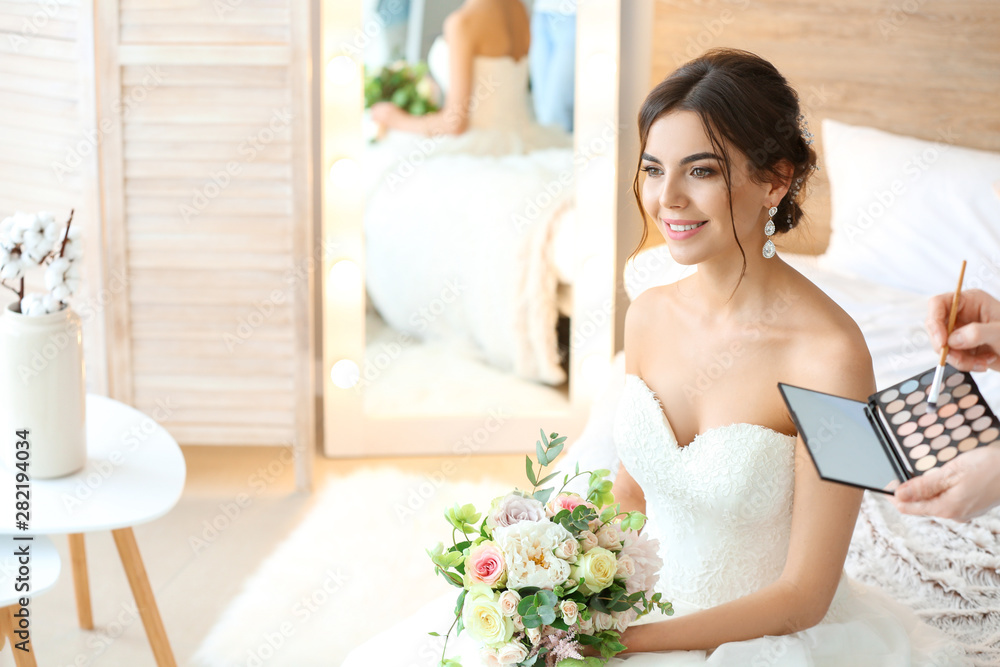 Professional makeup artist working with young bride at home Professional makeup artist working with young bride at home