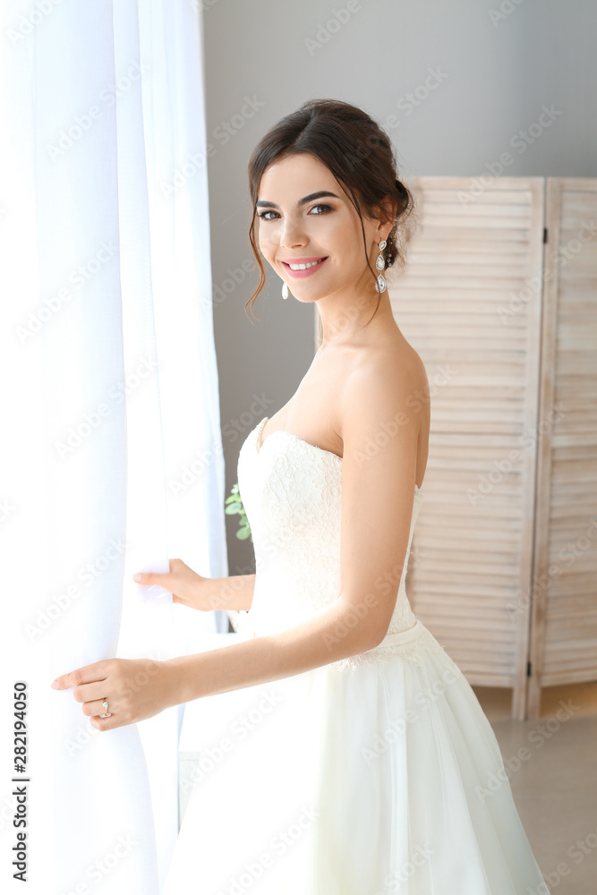 Beautiful young bride near window at home Beautiful young bride near window at home
