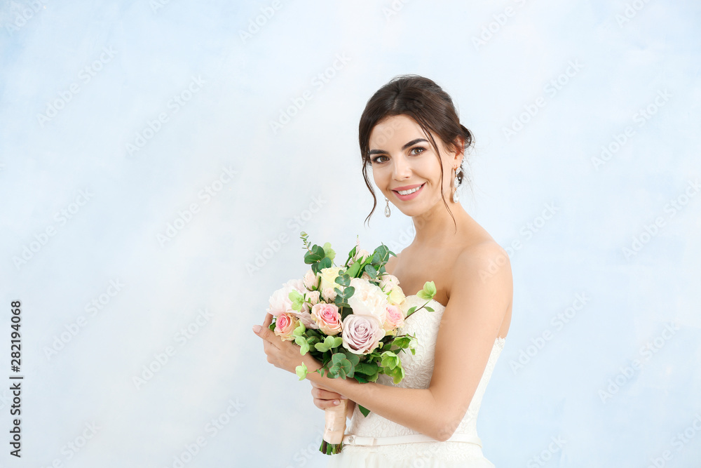 Beautiful young bride with bouquet of flowers on light background Beautiful young bride with bouquet of flowers on light background