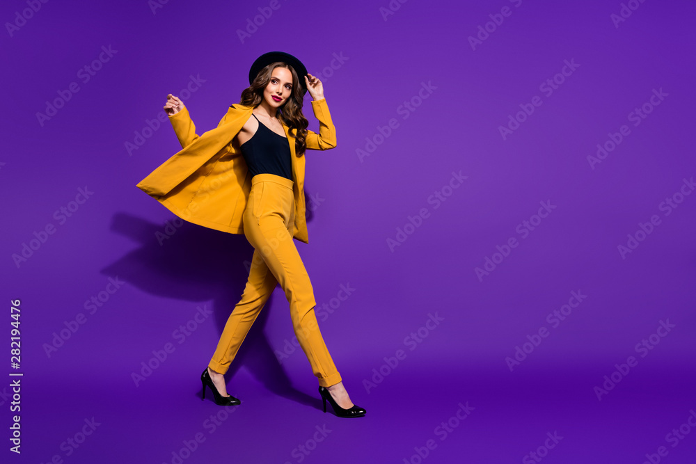 Profile side full length body size view of nice-looking gorgeous attractive content cheerful cheery wavy-haired lady motion touching hat isolated over bright vivid shine violet lilac background Profile side full length body size view of nice-looking gorgeous attractive content cheerful cheery wavy-haired lady motion touching hat isolated over bright vivid shine violet lilac background
